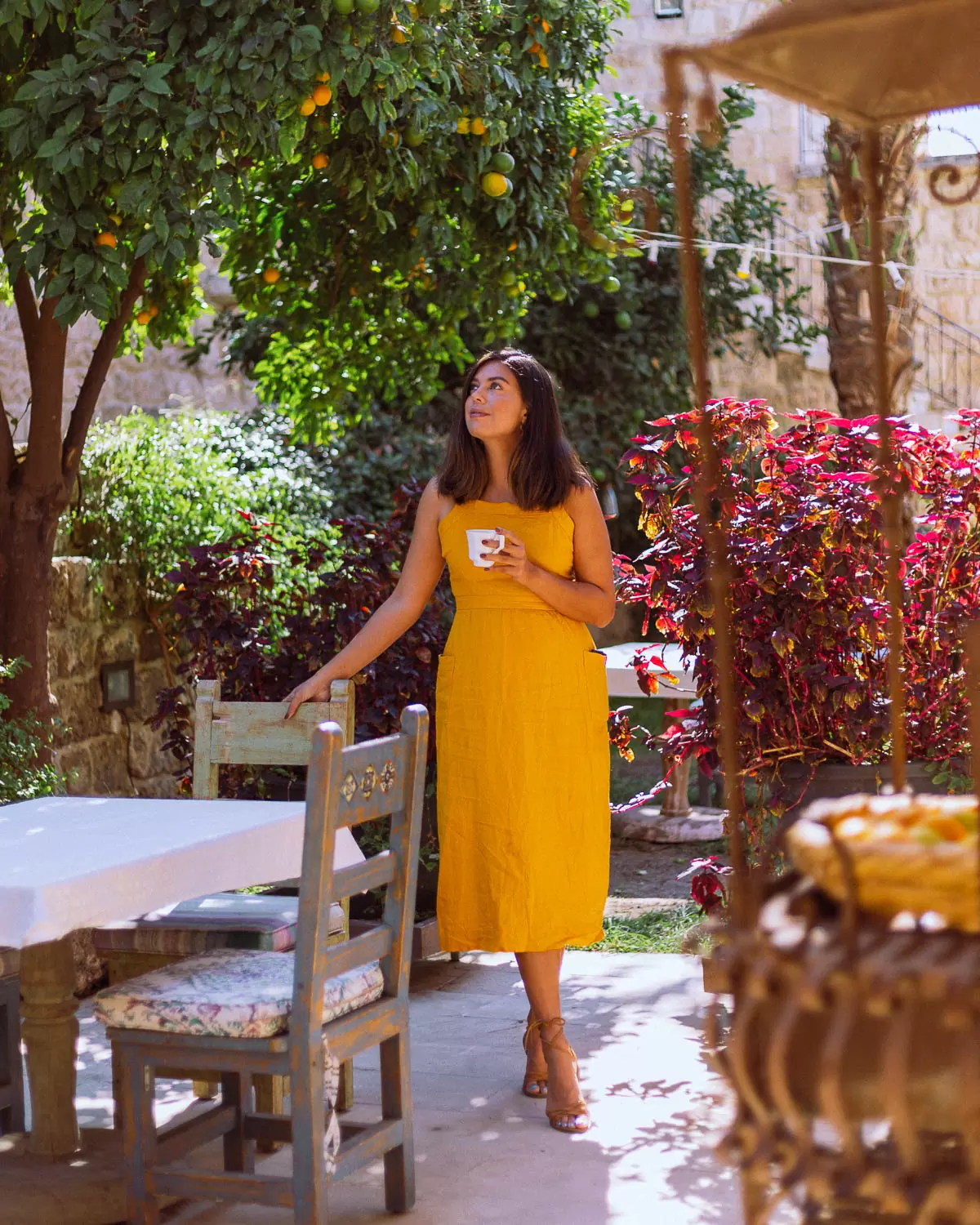 A Woman in Yellow Enjoying the Garden at Beit Lucida Wadih in Byblos